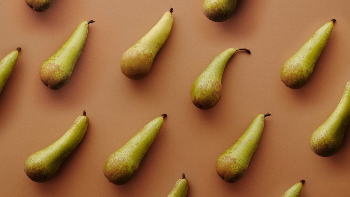 A minimalistic flat lay of pears on a brown background, perfect for food patterns.